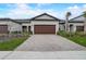 Modern home with a brick driveway and a two-car garage at 31396 Cabana Rye Ave, San Antonio, FL 33576