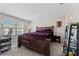 Cozy bedroom featuring a dark wood frame bed, window with blinds, and carpeted flooring at 9658 Sweetwell Pl, Riverview, FL 33569