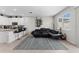 Open-concept living room with a comfortable black couch, patterned rug, and natural light from the window at 9658 Sweetwell Pl, Riverview, FL 33569