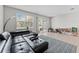 Bright living room featuring a black sectional, sliding glass doors to the patio, and modern decor at 9658 Sweetwell Pl, Riverview, FL 33569