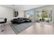 Spacious living room with a large black sectional sofa, area rug, and sliding glass doors to the patio at 9658 Sweetwell Pl, Riverview, FL 33569
