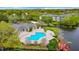 Aerial view of community pool, clubhouse, and surrounding landscape at 4115 Chatham Oak Ct # 218, Tampa, FL 33624