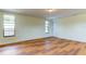 Bedroom with wood-look floors, large window, and exterior access at 7820 Sycamore Dr, New Port Richey, FL 34654