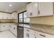 Modern kitchen with white cabinets, granite countertops and stainless steel appliances at 7820 Sycamore Dr, New Port Richey, FL 34654