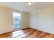 Bright bedroom with wood-look floors, large window, and built-in closet at 7820 Sycamore Dr, New Port Richey, FL 34654
