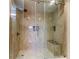Spacious walk-in shower with glass doors and tiled seating at 7820 Sycamore Dr, New Port Richey, FL 34654