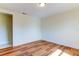 Simple bedroom with wood-look floors and access to the hallway at 7820 Sycamore Dr, New Port Richey, FL 34654