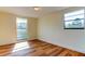 Sunlit bedroom with wood-look floors and a large window at 7820 Sycamore Dr, New Port Richey, FL 34654