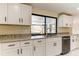 Updated kitchen with granite countertops, white cabinets, and stainless steel appliances at 7820 Sycamore Dr, New Port Richey, FL 34654