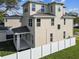 Tan three story house with a covered patio and white fence at 1323 W Arch St, Tampa, FL 33607