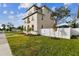 A three-story house with light beige siding, palm trees, and a white fence at 1323 W Arch St, Tampa, FL 33607