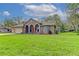 Single-story house with arched entryway and well-manicured lawn at 2409 Heather Manor Ln, Lutz, FL 33549