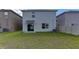 Expansive backyard featuring a well-maintained lawn and sliding glass door entrance at 2855 Maiden Grass Isle, Wesley Chapel, FL 33543