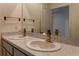 Bathroom featuring double sinks, decorative faucets, and a white speckled countertop at 2855 Maiden Grass Isle, Wesley Chapel, FL 33543