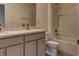 Bathroom with double sinks, white cabinets, and a bathtub with shower at 2855 Maiden Grass Isle, Wesley Chapel, FL 33543
