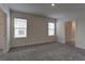 Spacious bedroom with plush carpeting, two windows, and neutral walls at 2855 Maiden Grass Isle, Wesley Chapel, FL 33543