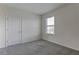 Bedroom with neutral carpet, a bright window view, and a paneled door at 2855 Maiden Grass Isle, Wesley Chapel, FL 33543