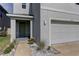 Welcoming front entrance with a charming green door and well-kept landscaping at 2855 Maiden Grass Isle, Wesley Chapel, FL 33543