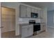 Updated kitchen with stainless steel appliances, modern gray cabinets, and granite countertops at 2855 Maiden Grass Isle, Wesley Chapel, FL 33543