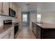 Modern kitchen boasts stainless steel appliances, granite countertops, and tile backsplash at 2855 Maiden Grass Isle, Wesley Chapel, FL 33543