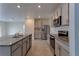 Modern kitchen features stainless steel appliances, gray cabinets, and granite countertops at 2855 Maiden Grass Isle, Wesley Chapel, FL 33543