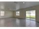 Spacious living area with tile flooring, multiple windows and a sliding glass door at 2855 Maiden Grass Isle, Wesley Chapel, FL 33543