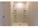 Bright shower with white tile surround and built-in shelving at 2855 Maiden Grass Isle, Wesley Chapel, FL 33543