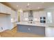 Modern kitchen with white cabinets and large center island at 3659 Tea Leaf Aly, Land O Lakes, FL 34638