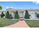 Mid-century modern home featuring a light gray exterior and lush landscaping at 1215 S Keene Rd, Clearwater, FL 33756