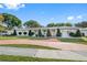 Single-story home with manicured lawn, large driveway, and mature landscaping at 1215 S Keene Rd, Clearwater, FL 33756