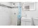 Clean bathroom with a shower, white vanity, and marble tile at 1215 S Keene Rd, Clearwater, FL 33756