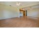 Open living and dining area with light laminate floors and kitchen access at 5390 Magnolia N Trl, Pinellas Park, FL 33782