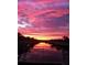 Vibrant sunset reflects over the canal waters, seen from backyard at 406 Islebay Dr, Apollo Beach, FL 33572