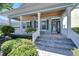 Inviting front porch with white columns, ceiling fan, and lush landscaping at 406 Islebay Dr, Apollo Beach, FL 33572