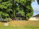 View of home from the backyard, partially obscured by trees at 9818 Morris Glen Way, Temple Terrace, FL 33637