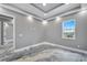 Bright bedroom features stylish gray walls, tray ceiling with fan and recessed lights, and a unique epoxy floor at 534 Estuary Shore Ln, Apollo Beach, FL 33572