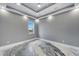 Bright bedroom features stylish gray walls, tray ceiling with fan and recessed lights, and a unique epoxy floor at 534 Estuary Shore Ln, Apollo Beach, FL 33572