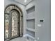 Close-up of the entryway with custom iron door, sleek shelves, and modern lighting at 534 Estuary Shore Ln, Apollo Beach, FL 33572