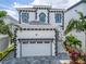 Two-story exterior view of a beautiful home with paver driveway, two-car garage and decorative wrought iron front door at 534 Estuary Shore Ln, Apollo Beach, FL 33572