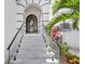 A grand front entrance features a decorative wrought iron door, glass railings, and stairs with black metal handrails at 534 Estuary Shore Ln, Apollo Beach, FL 33572