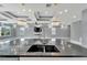 Close-up view of kitchen island and sink and a view of the living area and fireplace at 534 Estuary Shore Ln, Apollo Beach, FL 33572