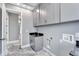 Laundry area with gray shaker cabinets and countertop, plus epoxy floors, and utility connections at 534 Estuary Shore Ln, Apollo Beach, FL 33572