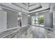 Spacious main bedroom featuring tray ceilings, recessed lighting, gray walls, and access to a balcony at 534 Estuary Shore Ln, Apollo Beach, FL 33572