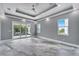 Spacious main bedroom featuring tray ceilings, recessed lighting, gray walls, and access to a balcony at 534 Estuary Shore Ln, Apollo Beach, FL 33572