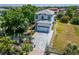 Two-story house with gray and white exterior, paved driveway, and tropical landscaping at 548 Estuary Shore Ln, Apollo Beach, FL 33572