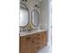 Light wood bathroom vanity with double sinks and oval mirrors at 213 W Giddens Ave, Tampa, FL 33603