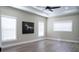 Spacious bedroom featuring wood floors, three windows, ceiling fan, and modern decor at 213 W Giddens Ave, Tampa, FL 33603