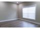 Bright, clean bedroom featuring a large window, fresh paint, and modern hardwood floors at 213 W Giddens Ave, Tampa, FL 33603