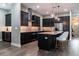 Modern kitchen featuring dark cabinets, stainless steel appliances, and a center island with seating at 213 W Giddens Ave, Tampa, FL 33603