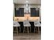 A modern kitchen showcases dark cabinets, stylish pendant lights, and a sleek island with seating at 213 W Giddens Ave, Tampa, FL 33603